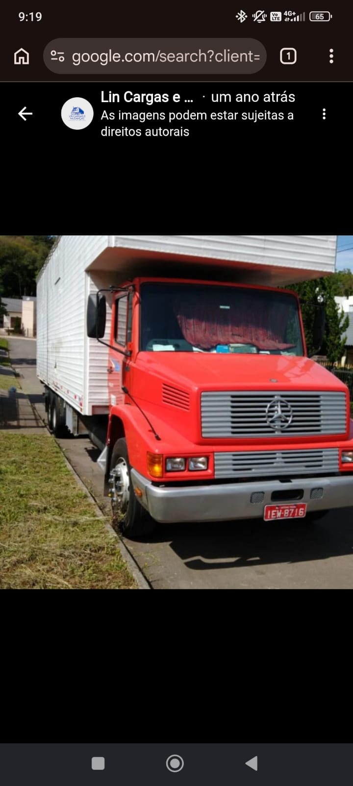Caminhão baú grande da Lincargas, cabine vermelha e baú branco, estacionado na rua