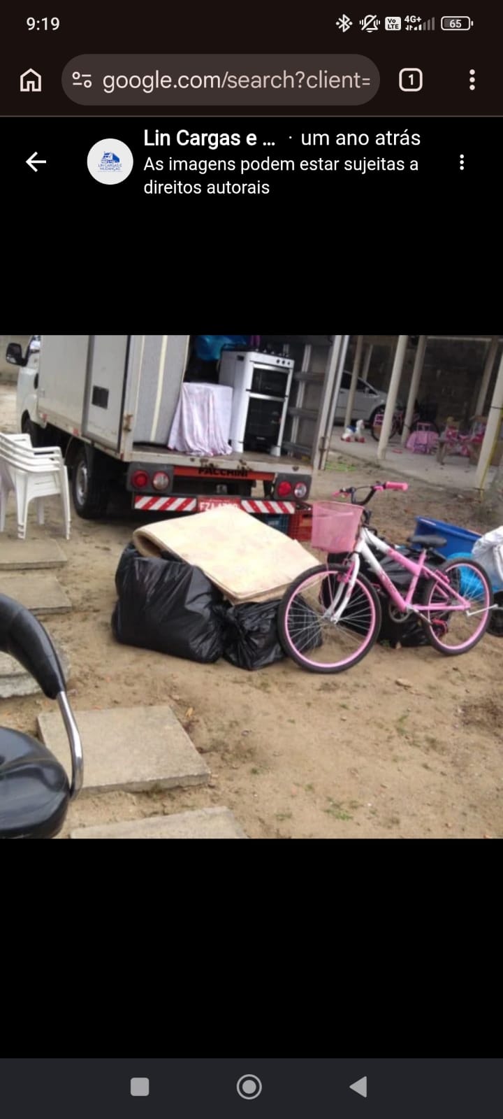 Coleta de mudança com caminhão pequeno: fogão e móveis já no baú, colchão e bicicleta esperando para subir